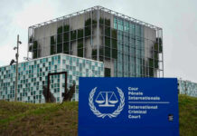 White House Declares ICC a Security Threat International Criminal Court building with sign in foreground.