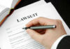 Telehealth Pill Mill Unleashed Hand holding pen, filling out lawsuit form.
