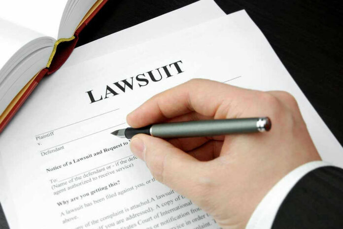 93505333-1 Hand holding pen, filling out lawsuit form.