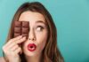 Bionic Eye Approved—Seniors Reads Again Woman holding chocolate bar over one eye against teal background