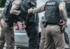 Most Wanted Down—Kingpin Found Police officers arresting a person beside a car