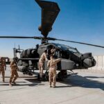 U.S. Troops Killed—Retaliation Spirals Soldiers inspect a military attack helicopter on a tarmac