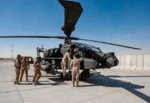 U.S. Troops Killed—Retaliation Spirals Soldiers inspect a military attack helicopter on a tarmac