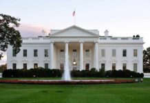 America-First Demands Hit Iraq Talks The White House with a fountain in the foreground and an American flag flying