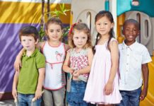 YMCA Scrubs Gender Pledge — Why Now? Five children standing together in a playground setting, smiling at the camera