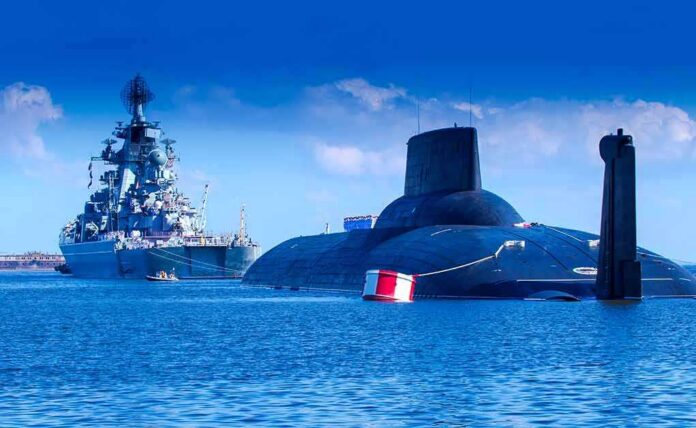 shutterstock_694442641 A submarine and a warship in the ocean under a blue sky
