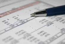 Close-up of a financial document with highlighted numbers and a pen