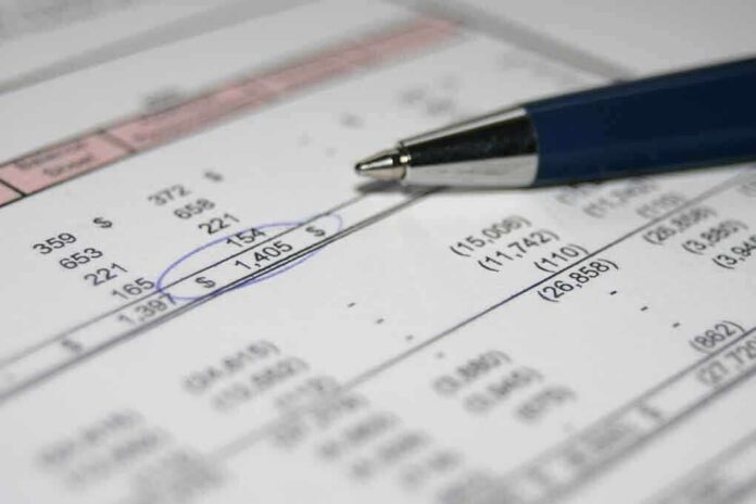 Close-up of a financial document with highlighted numbers and a pen