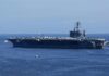 Overboard Alarms Expose Hidden Navy Crisis Aircraft carrier at sea with crew lining the deck