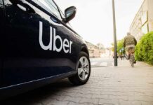 Uber-branded car parked on city street near cyclist