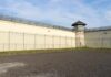 Prison yard with chain-link fence and guard tower