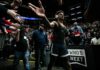 Basketball player in headphones high-fives fans while walking past crowd