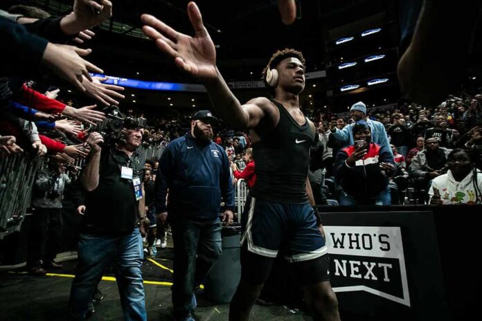 shutterstock_1593580081 Basketball player in headphones high-fives fans while walking past crowd
