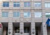 Flip-Flop Firestorm Engulfs Klobuchar US government building facade with flags and number 500