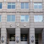Flip-Flop Firestorm Engulfs Klobuchar US government building facade with flags and number 500