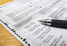 Ballot paper with pen on wooden surface