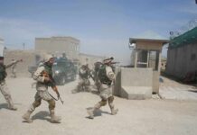 Stunning Bounty Threat For Captured Troops Soldiers in desert uniforms run past a checkpoint amid dust