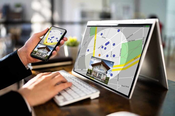 shutterstock_2122616261 Person using phone and laptop with real estate map app