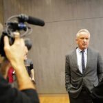 On-Air Meltdown: RFK Jr. vs. CNN Man in a gray suit speaks to a reporter during an interview