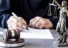 Ghislaine Maxwell’s Last Gambit CRUSHED In Court Judge writing at desk with gavel and Lady Justice statue
