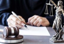 Ghislaine Maxwell’s Last Gambit CRUSHED In Court Judge writing at desk with gavel and Lady Justice statue