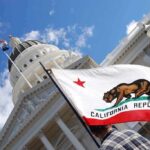 California state flag in front of a white domed capitol building