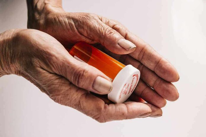 shutterstock_678422326 Older hands holding a prescription pill bottle
