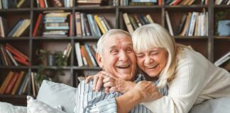 Older couple hugging and laughing on a couch