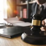 Plea Deal Twist Saves Antonio Brown Judge's gavel on desk with person reading documents in background