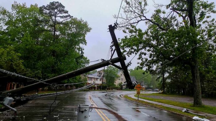 shutterstock_1093124054 Fallen utility poles blocking a wet suburban street