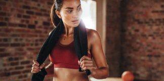 Woman in red workout clothes holding a towel in a gym