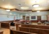 Judge Hammers $64M Medicaid Ringleader Empty courtroom with wooden benches and judge's bench