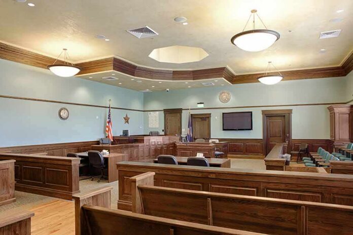 shutterstock_1349439551-4 Empty courtroom with wooden benches and judge's bench