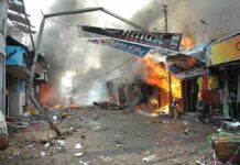 Missile Barrage Ignites Citywide Chaos Street marketplace engulfed in fire and heavy smoke