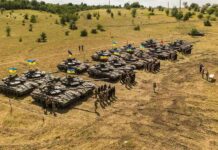 Putin Probe Rock NATO Rows of military tanks with soldiers assembled on a dry field