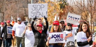 Group of protesters marching with political signs and hats
