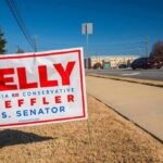 Political campaign yard sign beside a suburban road