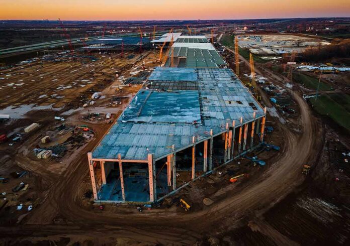 aerial view of large industrial building under construction at sunset