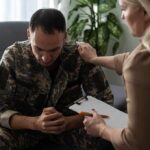 18 Veterans a Day — What’s Failing? Soldier in camouflage receives support from a counselor