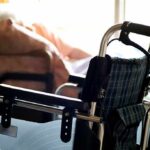 wheelchair near a bed in a sunlit room
