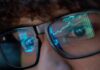 OpenAI’s Quiet Review Raises Alarms Close-up of a persons eyes with financial data reflected in their glasses