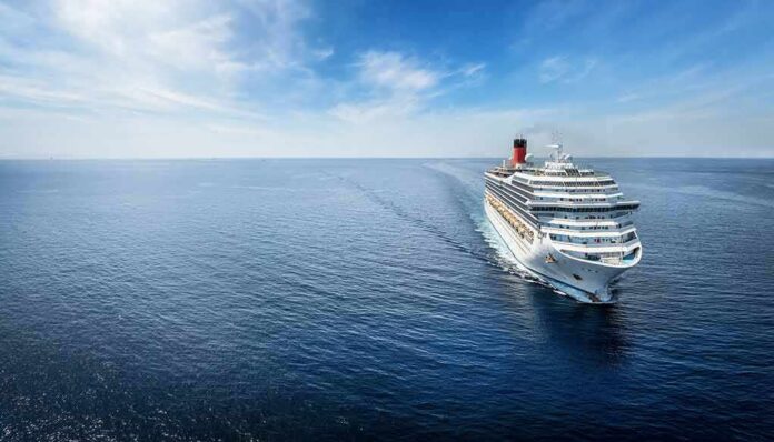 shutterstock_2388232903 Cruise ship sailing on calm blue ocean