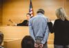 Russian Fraudster Exploits Election Loopholes Defendant in handcuffs stands before a judge in a courtroom