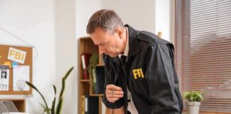 FBI agent reviewing documents at a desk