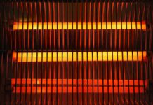Electric space heater with glowing heating elements behind a safety grille