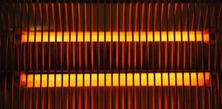 Electric space heater with glowing heating elements behind a safety grille