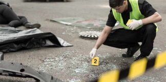 Forensic investigator marking evidence at crash scene