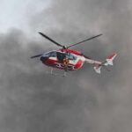 Rescue helicopter hovers amid thick smoke