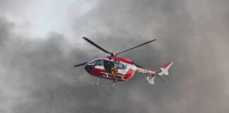 Rescue helicopter hovers amid thick smoke