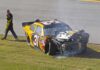 Racing Icon’s Mystery Brain Battle Race car with heavy front-end damage on grass